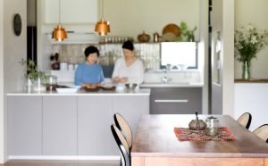 ダイニングテーブルから見た、親子で料理を楽しむキッチン風景。家族が集まりやすい開放的なLDK。