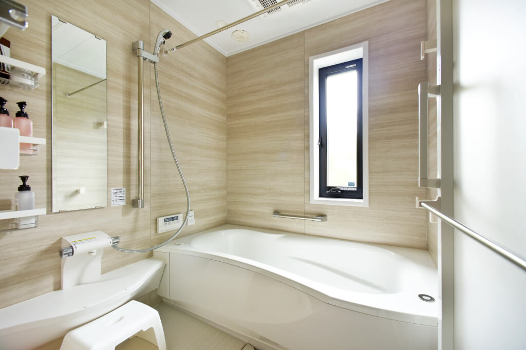 トクラスの清潔感あふれるバスルーム。汚れが落ちやすい人造大理石のバスタブと木目調の壁パネル。