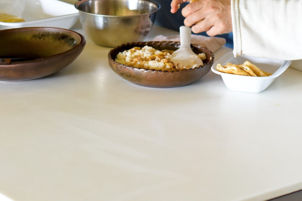 奥行き888mmの広いワーキングカウンターで料理を楽しむ様子。複数人での調理も余裕のある広さ。