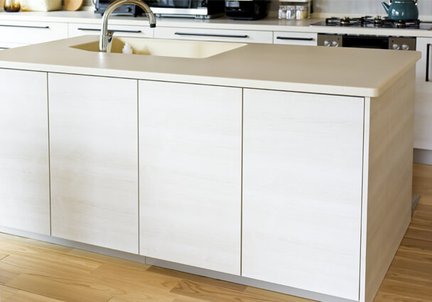 2列型キッチンのアイランドカウンター。大きなシンク付きで、白木目のデザインがおしゃれ。