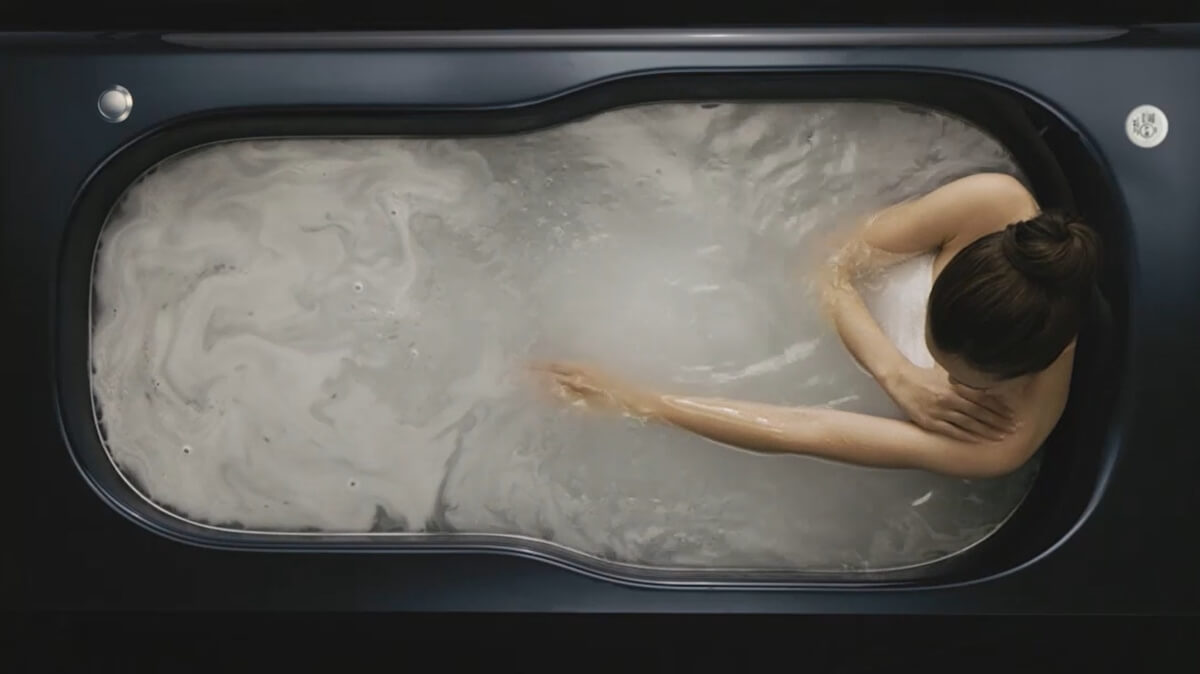 トクラスのバスタブでダブルバブルバスを楽しみながら、肩までしっかり浸かる全身浴をしてリラックスする女性