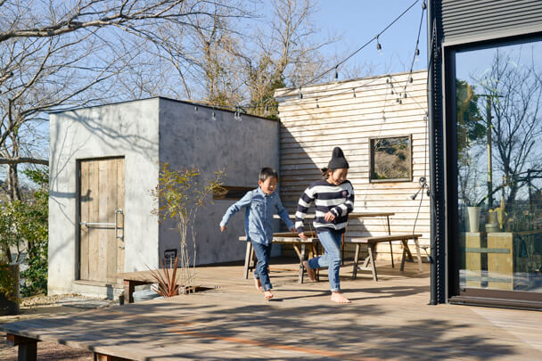 広いウッドデッキと庭で遊ぶ子供たち、DIYのある暮らし