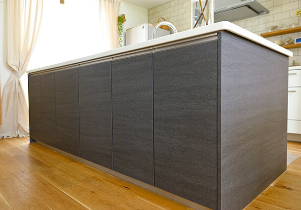 カフェのカウンターのような、ダークトーンのシックなアイランドキッチンの外観。