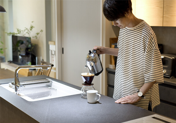 コーヒーを淹れる男性。家事効率のよいキッチンで趣味を楽しむ。