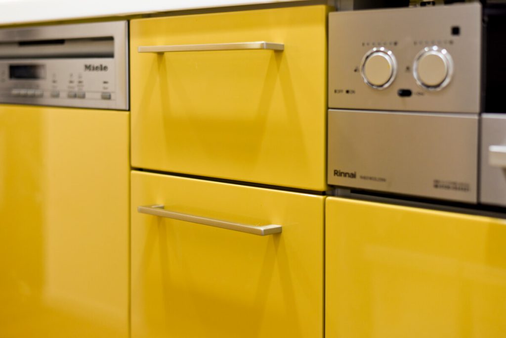 drawer-miele.jpg トクラスキッチンのシャインカラー「深支子」色の扉と、ビルトインされたミーレ（Miele）の食洗機。