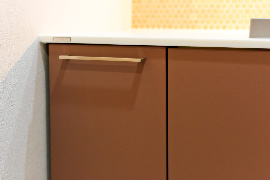 トクラス「Noare（ノーレ）」の扉に選んだ温かみのあるテラコッタカラーと、シンプルでモダンな取っ手の質感。