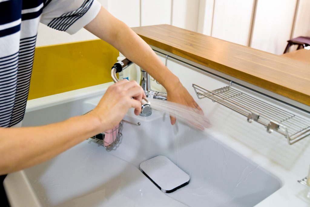 トクラスキッチンのハイバックカウンターでお手入れをする様子。継ぎ目のない一体成形で掃除がしやすい構造。