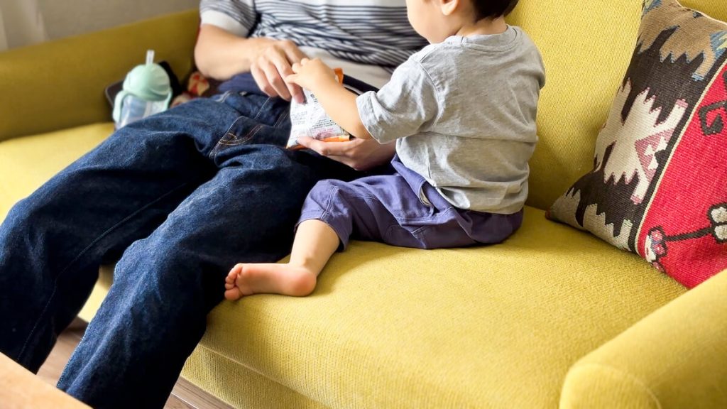 こだわりの黄色いソファでくつろぐ息子さん。家族の「一生もの」に囲まれた豊かな暮らし。