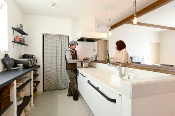 夫婦が一緒に料理や憩いの時間を楽しむクリーンなキッチン