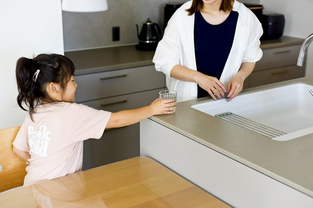 キッチンにいる親とダイニングテーブルに座る子どもが会話する様子。スムーズな動線。