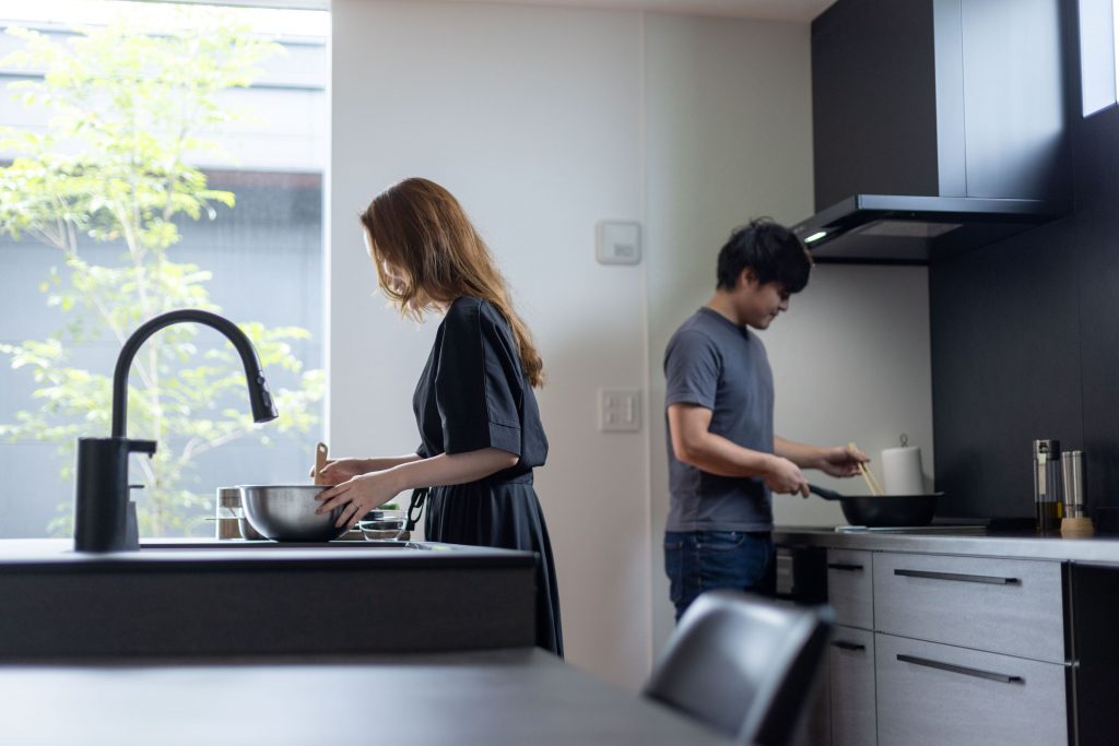 アイランドキッチンで協力して料理をするご夫婦。利便性の高いキッチンでのコミュニケーション。