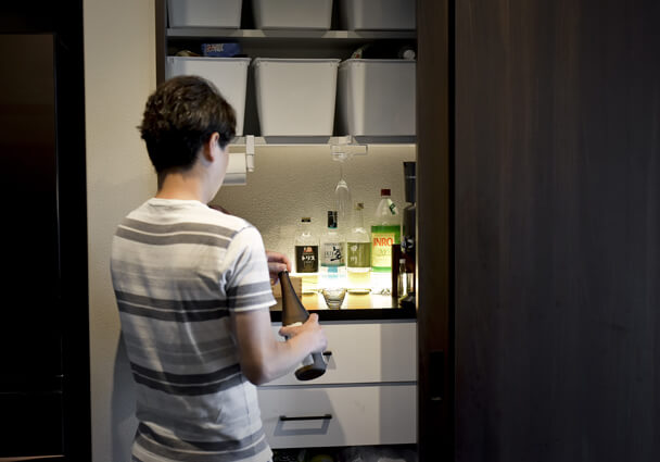 晩酌を楽しむための隠れた収納。お酒が並び、照明がおしゃれな大人のバースペース。