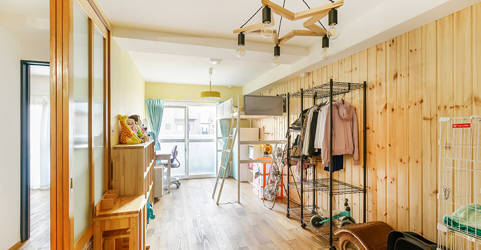 自然な木の壁とロフトベッド、収納を設けた、子育てに配慮した子供部屋
