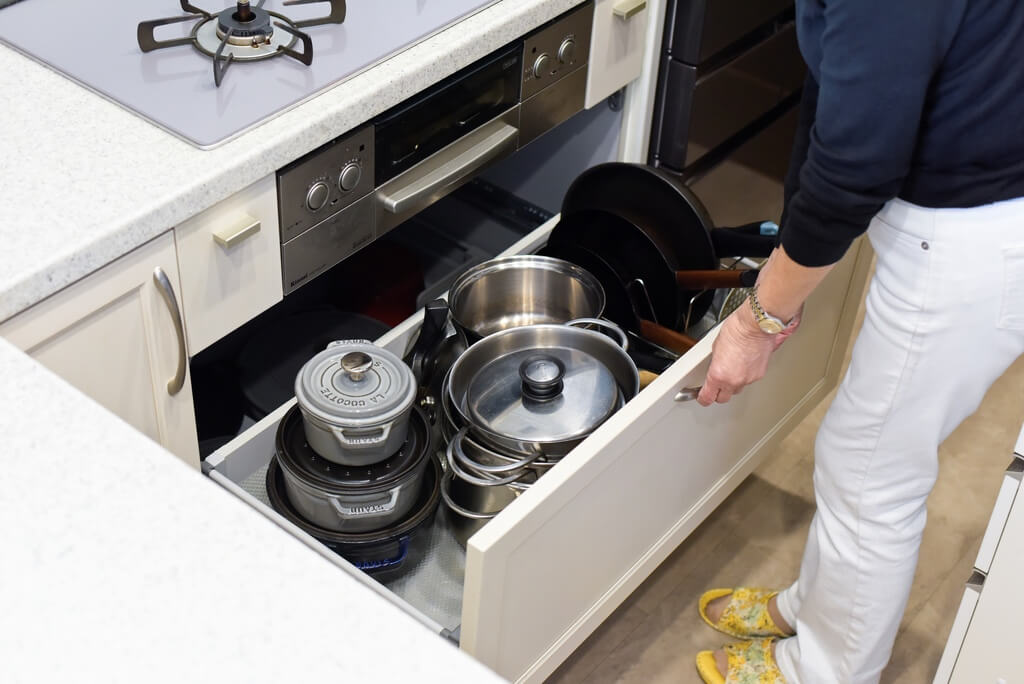 トクラスキッチンの深い引き出し収納に、鍋やフライパン、ステンレス調理器具が機能的に収まっている様子